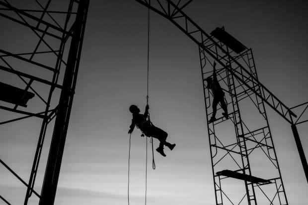 Male working abseiling on a construction site silhouette worker